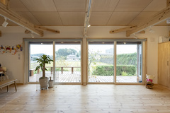 広々としたリビングで大きな窓から外の景色が望める。自然光を多く取り入れた開放的な空間で、室内と庭が一体となった魅力的な設計。