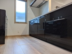 タカラスタンダードの黒を基調としたスタイリッシュなキッチン。広々とした作業スペースと収納の多さが魅力的な空間である。