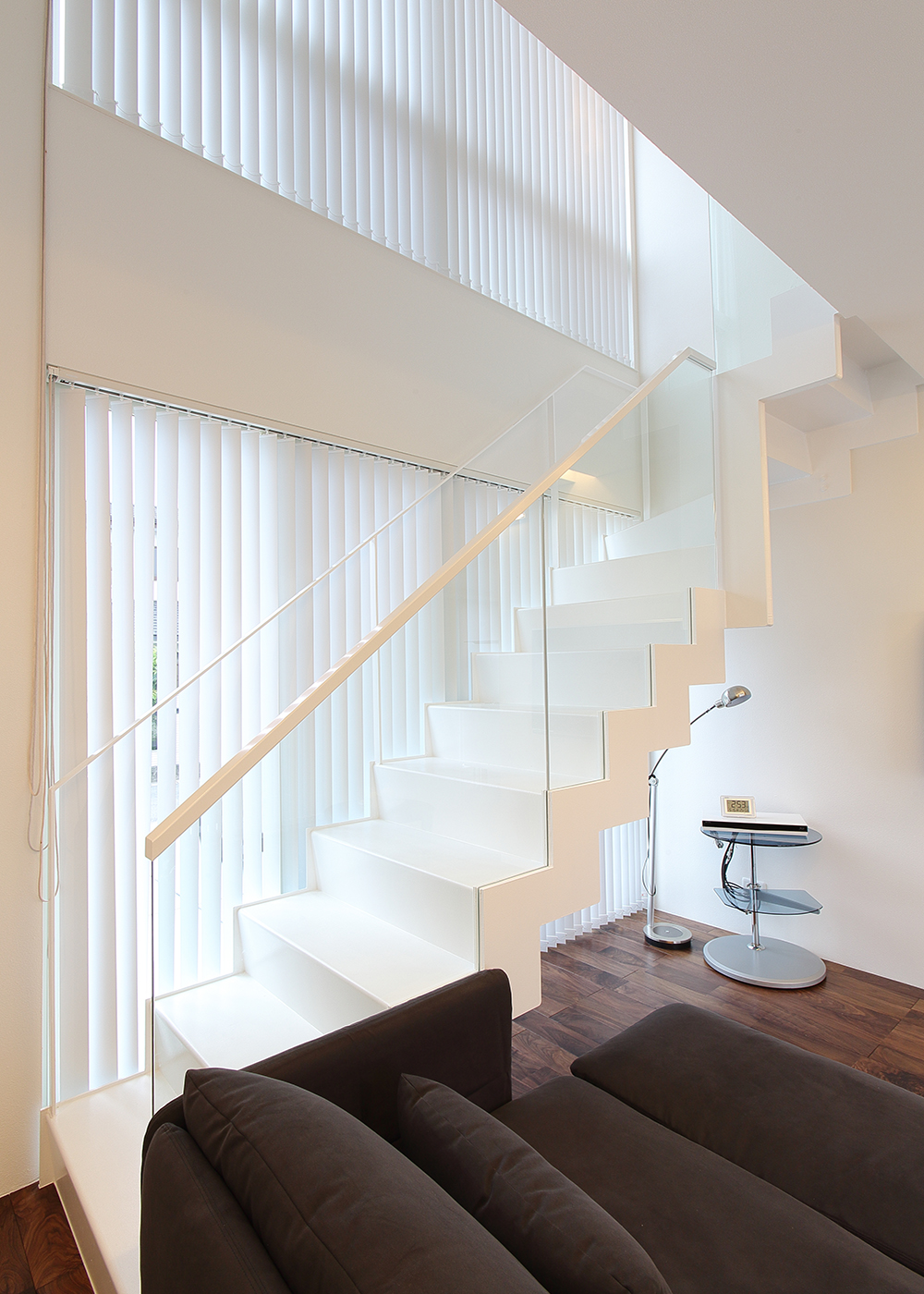 丸昇彦坂建設【デザイン住宅、間取り、ガレージ】スケルトンの手すりは2階の渡り廊下のものと統一され、流動的なデザインに。目線を遮られることなく、視覚的にも開放感を得られる。白が基調ながらも色の濃淡が違ったり、デティールまで意識することで空間が引き締まる