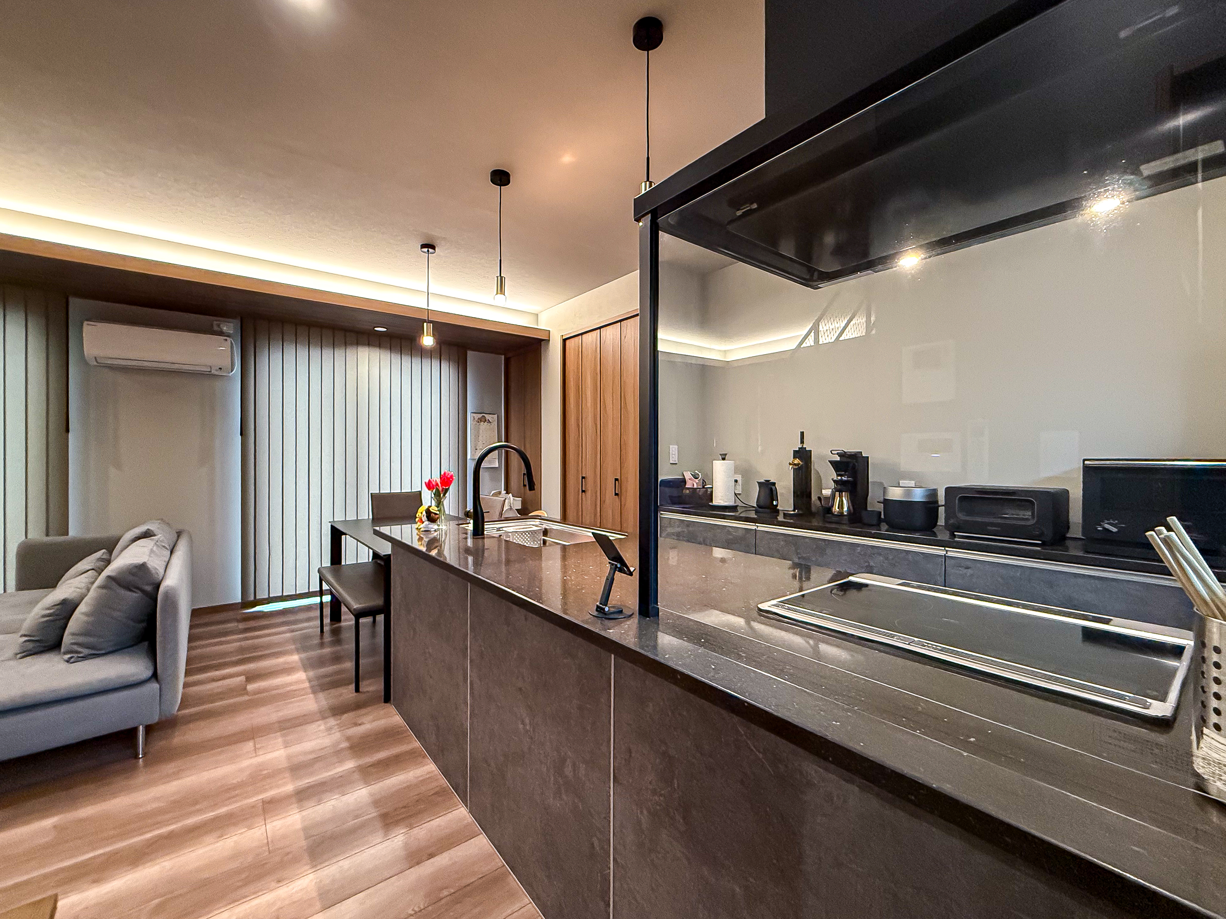 ロイヤルウッド｜落ち着いた色調のLDK空間。ゆったりとしたソファと食事を楽しめるダイニングが配置され、キッチンから全体を見渡せる配置が便利である。