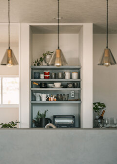 部屋全体と色味を合わせた造作収納。しまうものに合わせて棚の高さを調整し、使い勝手を高めた。照明はSさんの支給品を取り付け