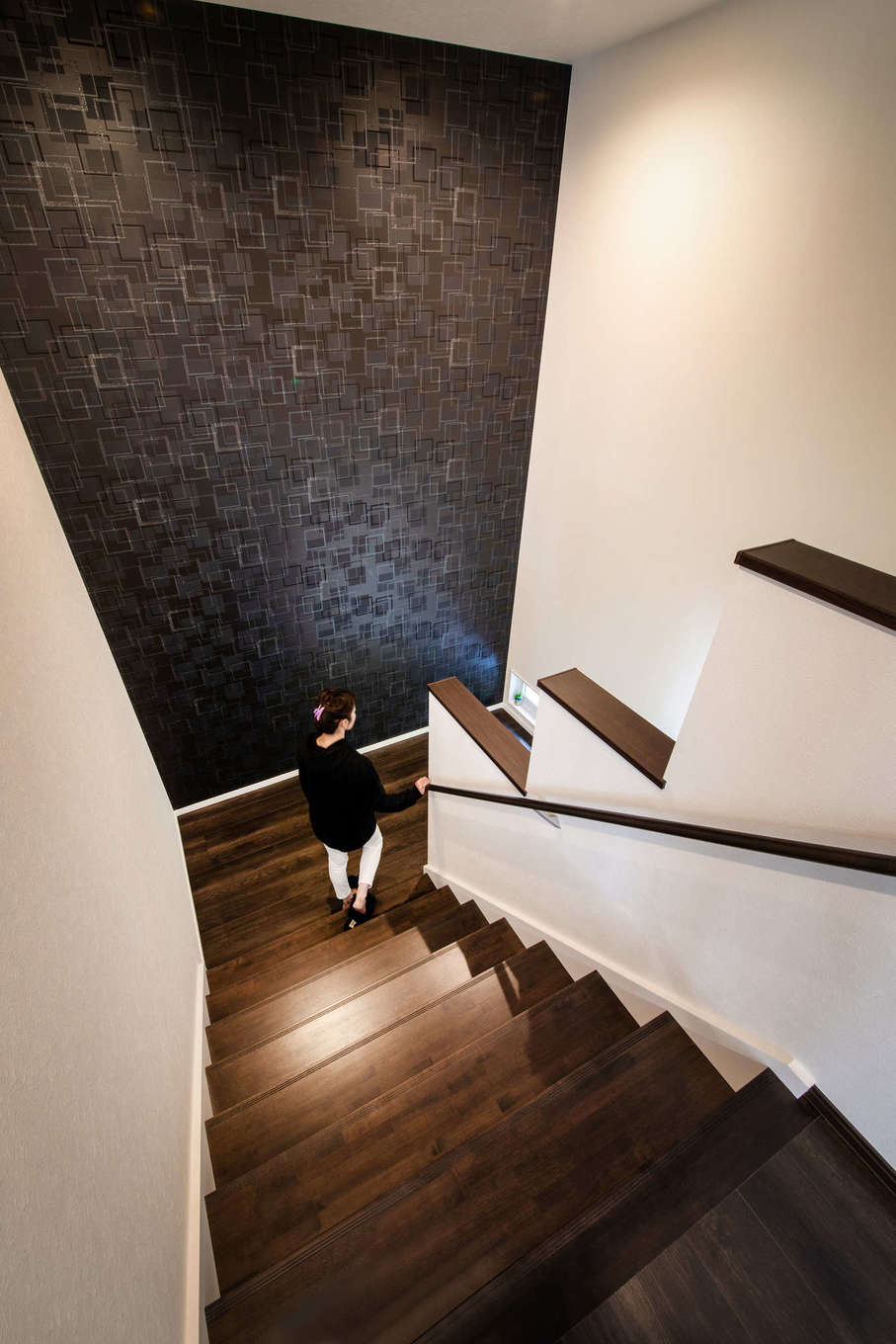 吉川住建【子育て、省エネ、ガレージ】幅1.5メートルの広い階段は、2人並んでも行き来が可能。天井まで至るアクセントクロスのスケール感に圧倒される