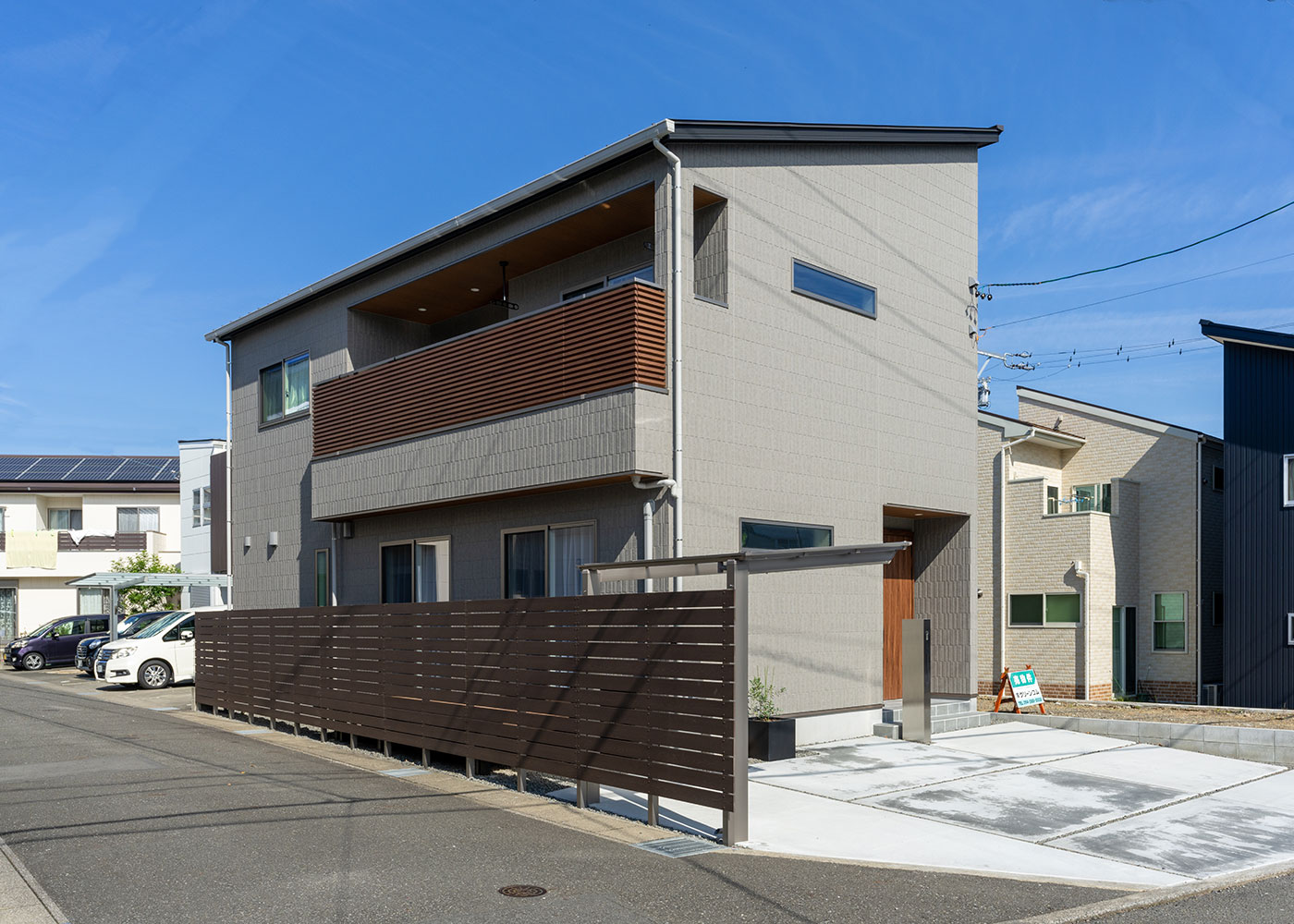 寺田工務店【デザイン住宅、省エネ、間取り】タイルの外壁をグレー系でまとめ、玄関ドアやベランダにはウッド系を使用。落ち着いた中にも木のぬくもりを感じられるやさしい外観に仕上がった