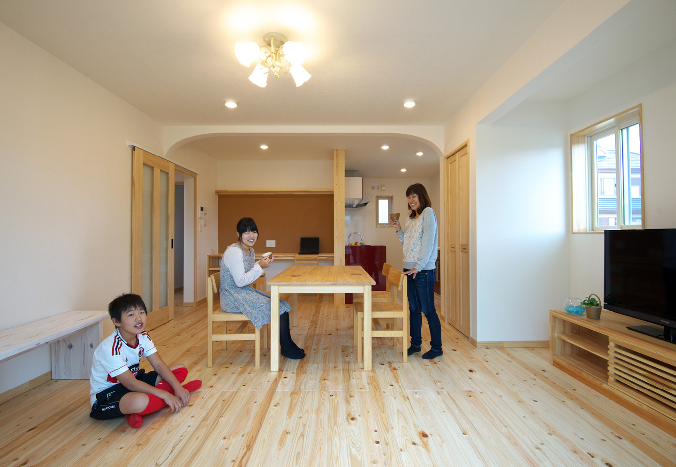 ワイズホーム｜築年数を感じさせる暗いLDKも、イメージ一新！ 追加した梁はR天井で隠し、耐震性とデザイン性を両立。シャンデリア風の照明器具は、娘さんがネットで選んだもの