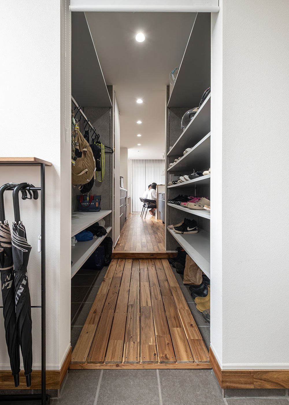 R＋house御殿場（岳南建設）【間取り、建築家、平屋】玄関を入った正面は、家族専用動線のシューズインクローク。バッグや上着などを収納するロッカーを造作して、お出かけ前や帰宅後の荷物の定位置をつくった。そのままキッチンに抜けられるので買い物帰りも便利