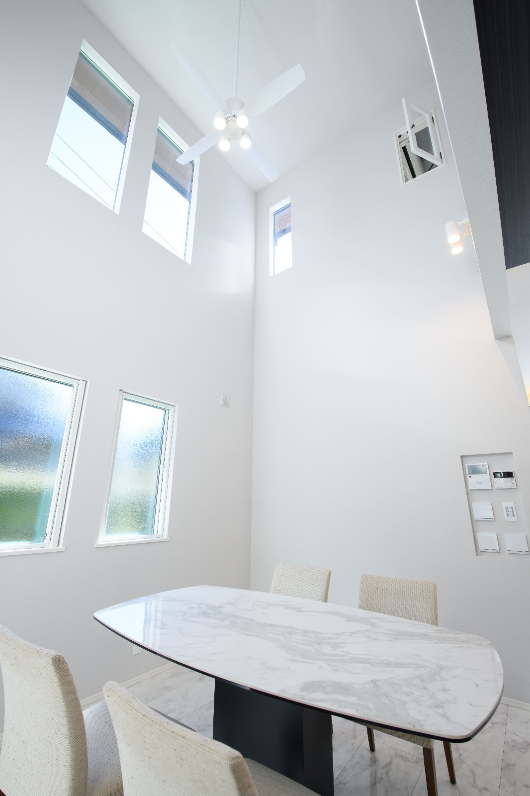 Sus∞Eco Home（サスエコホーム）｜天井が高く、自然光が差し込む明るいダイニング。モダンなデザインのテーブルと椅子が配され、開放感がある空間