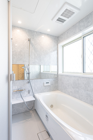 清潔感あふれるモダンなバスルーム。大きな窓から自然光が差し込み、ゆったりとしたバスタイムを楽しめる設計である。