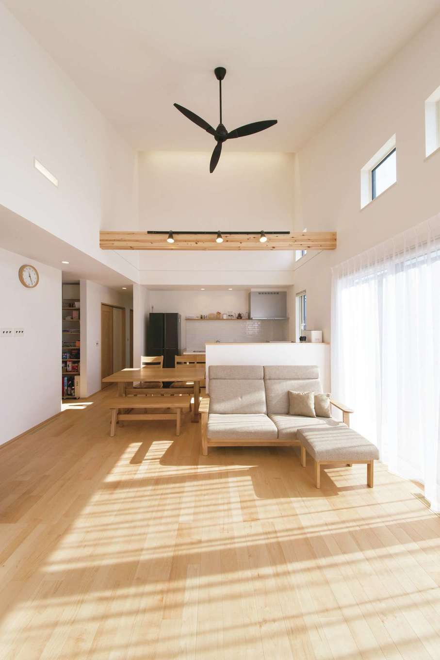 コットンハウス【子育て、省エネ、間取り】陽当たりのよい南側にはくつろぎ空間のLDKと寝室を配置。北側はパントリー・トイレ・洗面など生活設備を集中させ、ゾーニングしている。LDKは22畳の大空間ながら、ハイブリッド断熱と全館床下暖房で1年中快適。せっかくの広々空間に余分な家具を置かなくてもすむように、収納は綿密なプランですべて造り付けとしている