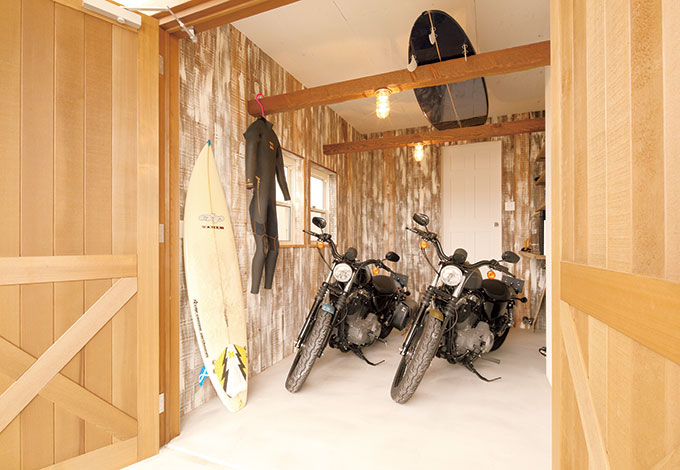 富士ホームズデザイン【デザイン住宅、趣味、自然素材】お揃いのバイクが並ぶガレージ。ムラを残して塗った板壁がいい味