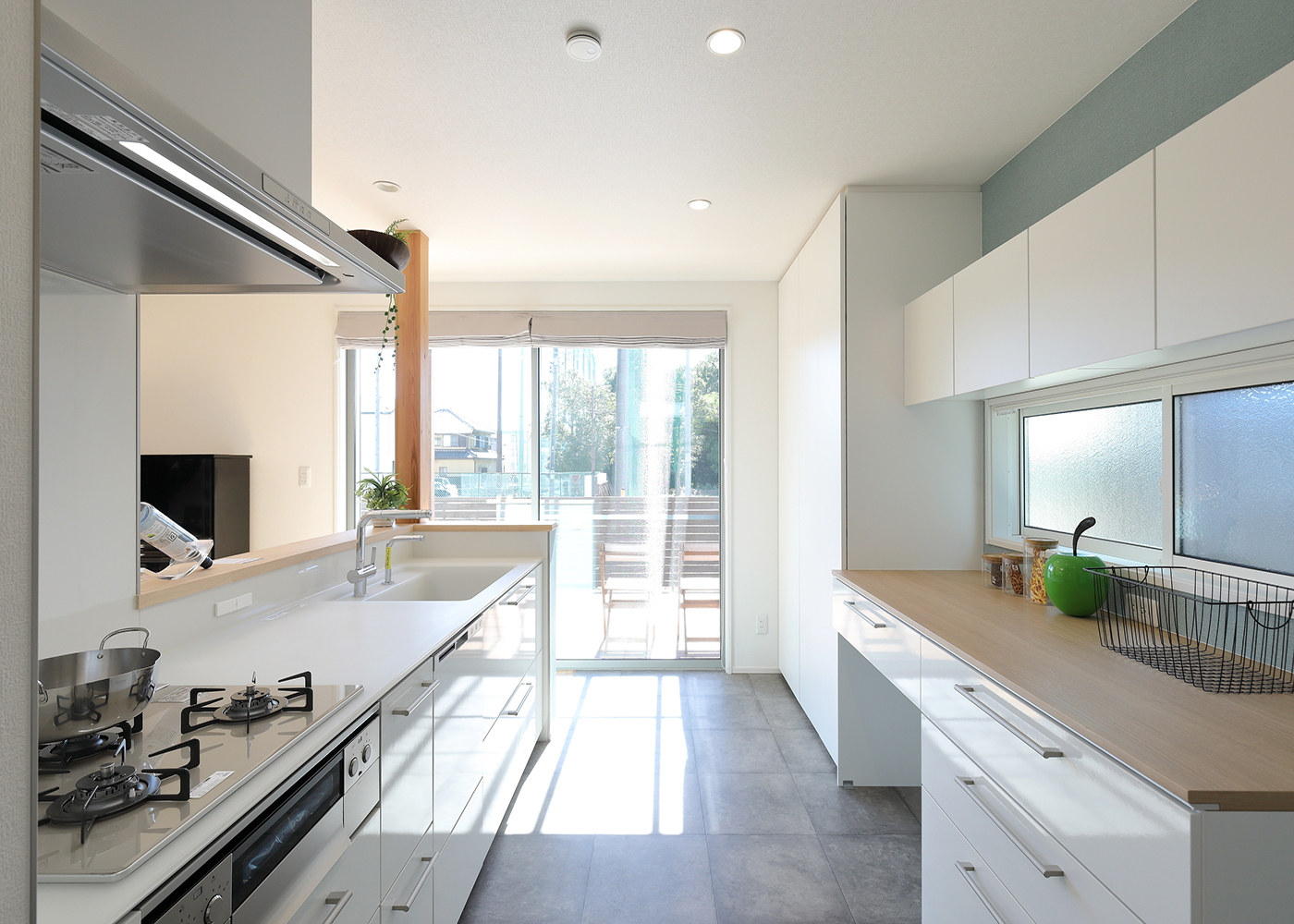 丸昇彦坂建設【デザイン住宅、趣味、間取り】ダイニングキッチンの南側にも掃出窓を設けてあるおかげで、キッチンまで明るさが行き届く。キッチンは白い扉にすることで清潔感あふれる空間が実現