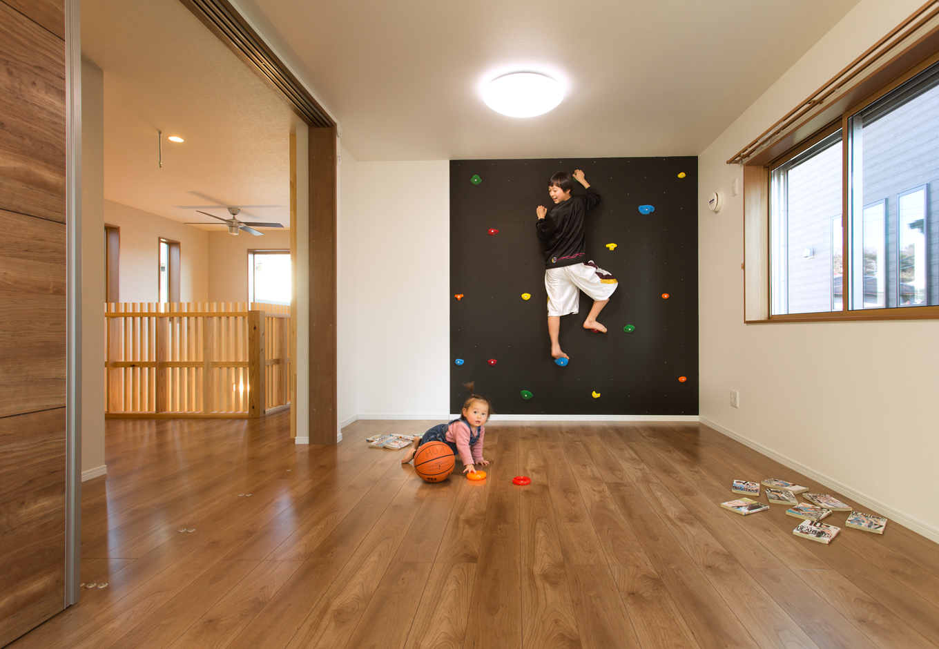 瀧口建設【子育て、自然素材、間取り】ボルダリングのコーナーを設けた子ども室。普段は廊下との仕切り戸をオープンにして広々と使用。「当面は女の子3人の部屋として使う予定なので、将来的に部屋を区切るにしてもカーテンで仕切る程度でいいかな…と思っています」と奥さま