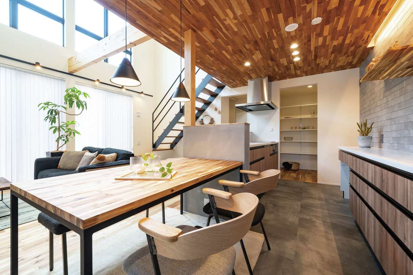 住家 JYUKA【デザイン住宅、ペット、建築家】キッチンの下がり天井は玄関ポーチと同じチーク材。バックカウンターのグレーの壁はイタリア製のタイル。吹抜けを通して2階の気配もわかるので安心