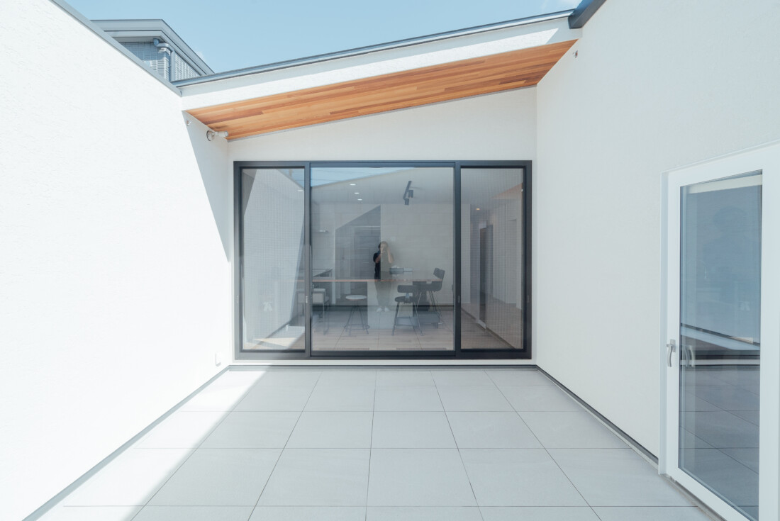 チェックハウス｜シンプルでスタイリッシュな中庭。建物内部と屋外をつなぐオープンスペースで、自然光がたっぷりと入る設計
