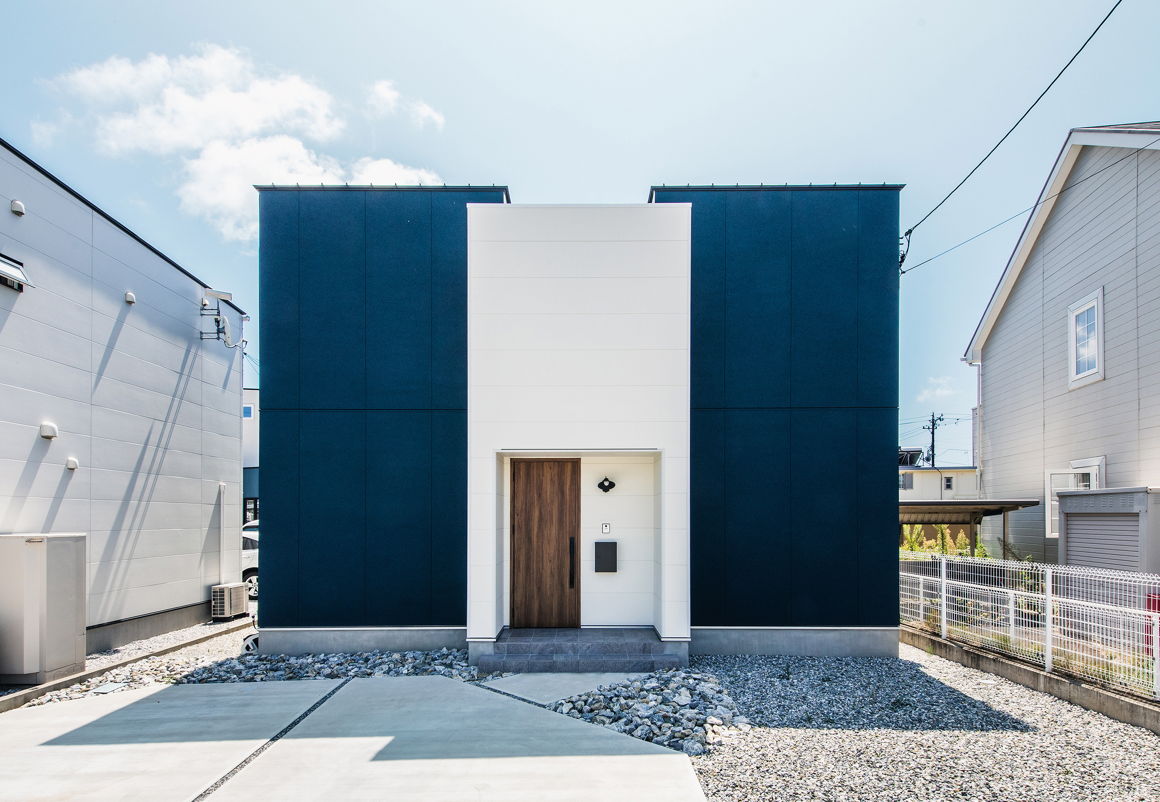 SEIEN ARCHITECT【趣味、建築家、1000万円台】白×ネイビーのコンビネーションが爽やかなキューブ型の2階建て。白い外壁の奥にバルコニーがあり、道路側の視線を遮ってプライベートなアウトドア空間を確保
