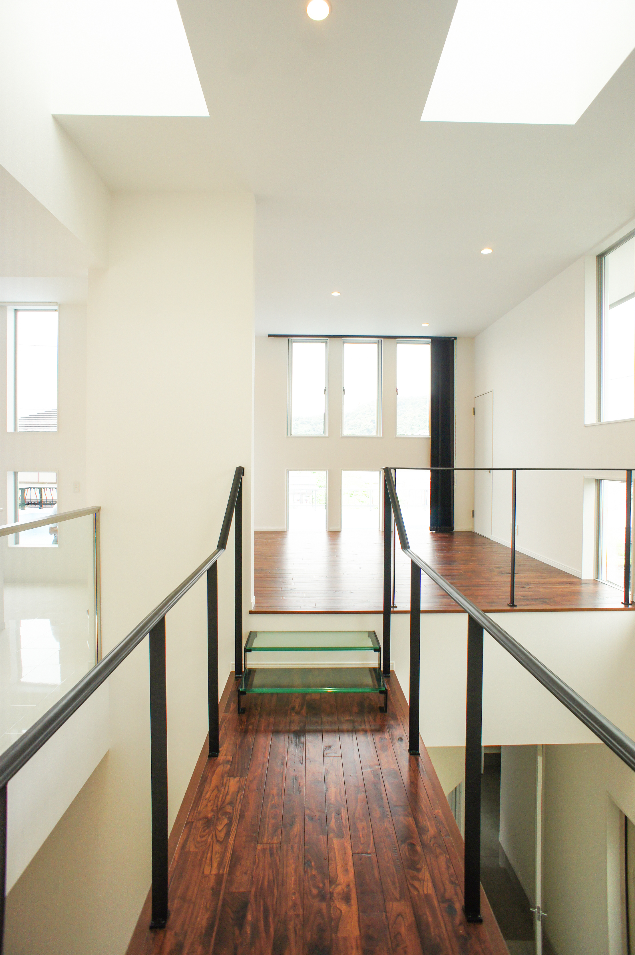 小野田産業～designers house project～｜天井からの採光が美しい廊下。手すりが開放感を演出し、モダンな雰囲気を醸し出すデザイン。