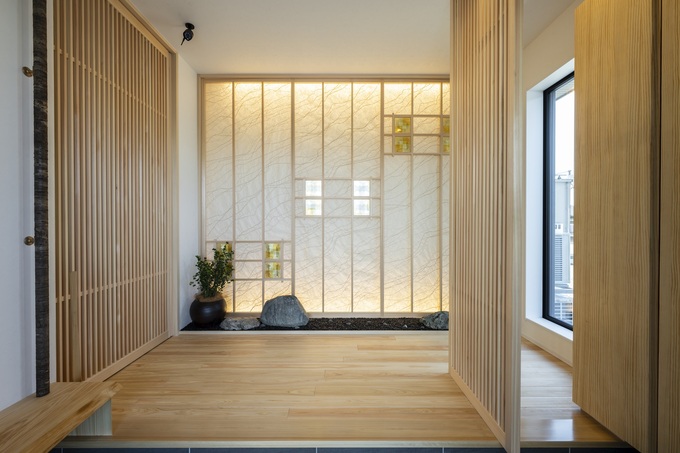 自然光がたっぷりと差し込む広々とした玄関ホール。木の温もりを感じさせるデザインとシンプルな装飾が調和している。落ち着いた雰囲気で来客を迎えるのに最適な空間。