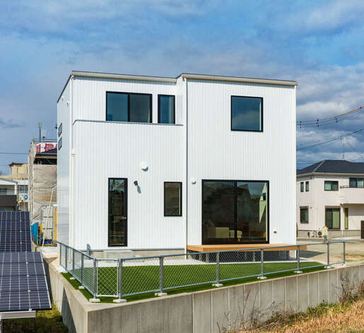 窓を大きくとり、光と風をたっぷりと招き入れる南側の外観。独特な土地形状を活かして、庭も広く確保できた。アメリカンフェンスもおしゃれ