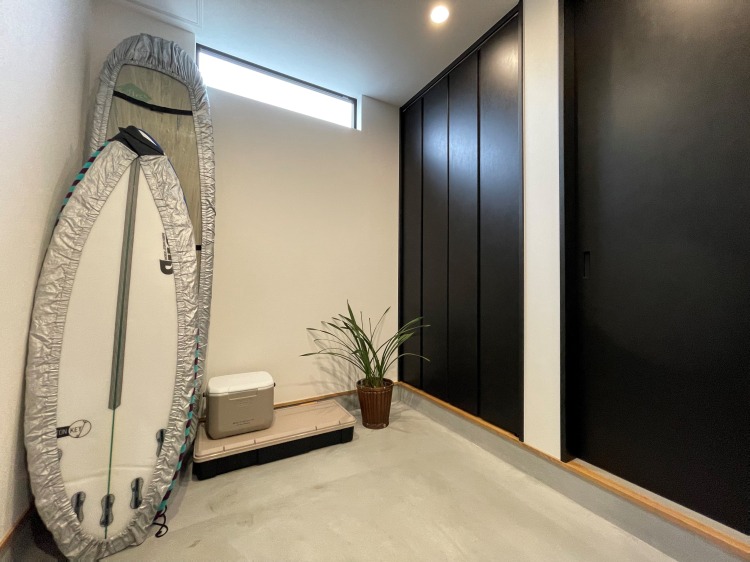 マツバラ工務店｜サーフボードが立てかけられたスタイリッシュな土間収納スペース。シンプルで使いやすいデザインが特徴的。