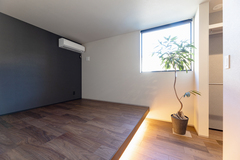 まるごと小上がりにした敷布団を敷くベッドルーム。
小上がりの部分には間接照明を取り入れ、光が柔らかく広がる落ち着きのある空間を演出。