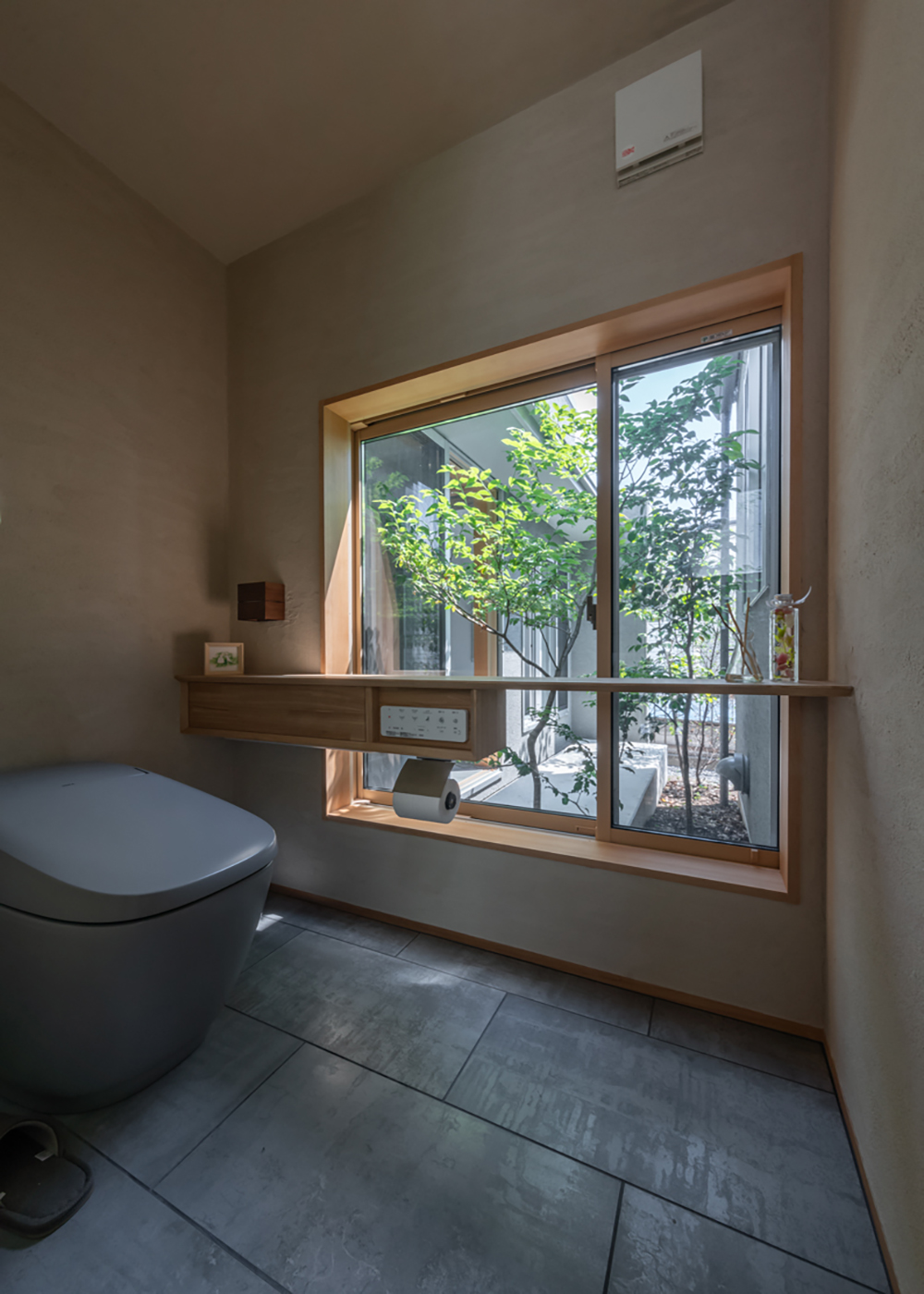 m+h（エムアンドエイチ）建築設計スタジオ【自然素材、建築家、平屋】中庭の緑を感じられるトイレ。隣家と目線が合わないよう計算し尽くされている