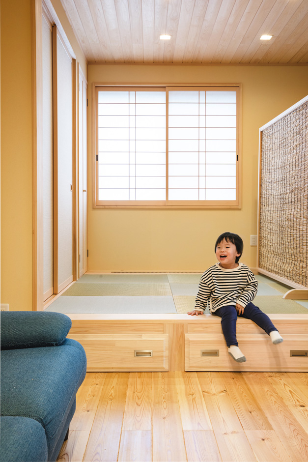 瀧口建設｜リビングに設けた小上がりの畳コーナーは、子どもたちの遊び場や家族の団らんスペースとして大活躍。床下の引き出しは１間分の奥行きがあり、荷物をたっぷり収納できる。リビングとの仕切りには、同社オリジナルのヨシズの衝立を利用