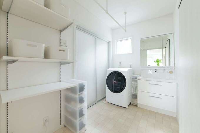 室内干しもできるようデザインされた洗面脱衣室兼ランドリールーム。天井に取り付けたランドリーパイプは、洗濯機から出してすぐにハンガーに衣類を掛けられるため、重宝しているそう