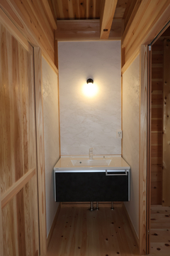 自然素材を活かした洗面スペース。木材のぬくもりが感じられるシンプルなデザインで、落ち着いた空間を演出している。