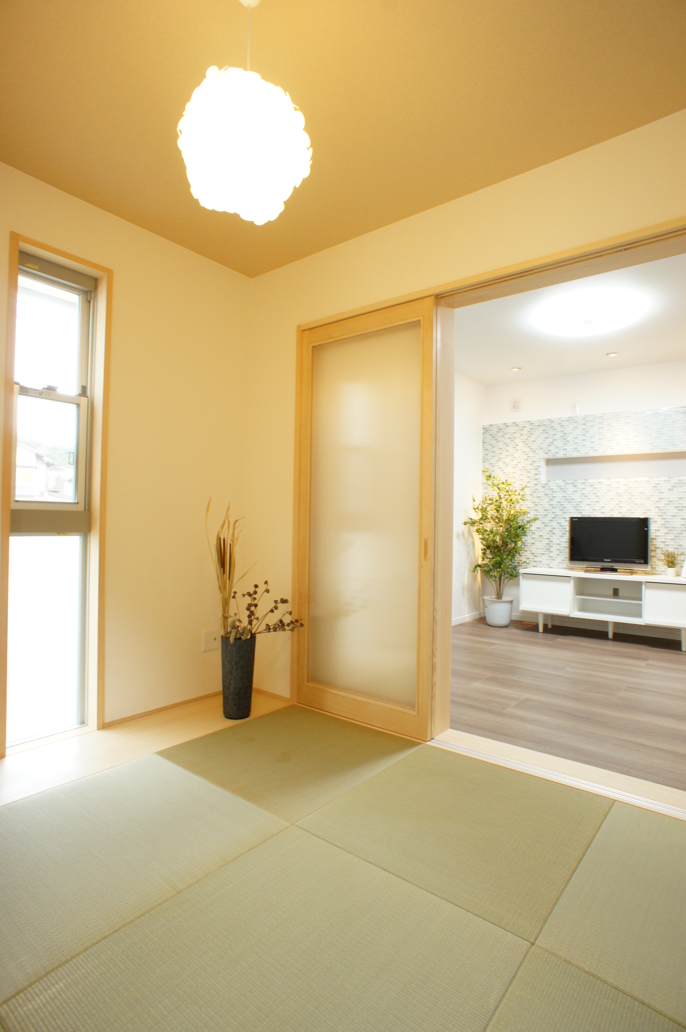 小野田産業～designers house project～｜モダンな和室の一角。畳の上に柔らかな光が差し込み、リビングと自然に繋がる開放的な空間を演出している。