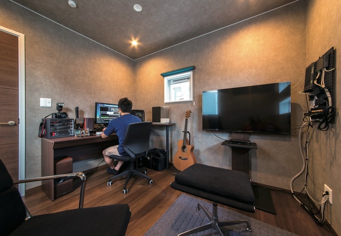 写真や音楽など、多趣味なご主人の書斎は、ダークカラーのフローリングとクロスを用いた。照明は調光可能で照度を落とせばシアターのような空間で映画鑑賞が楽しめる