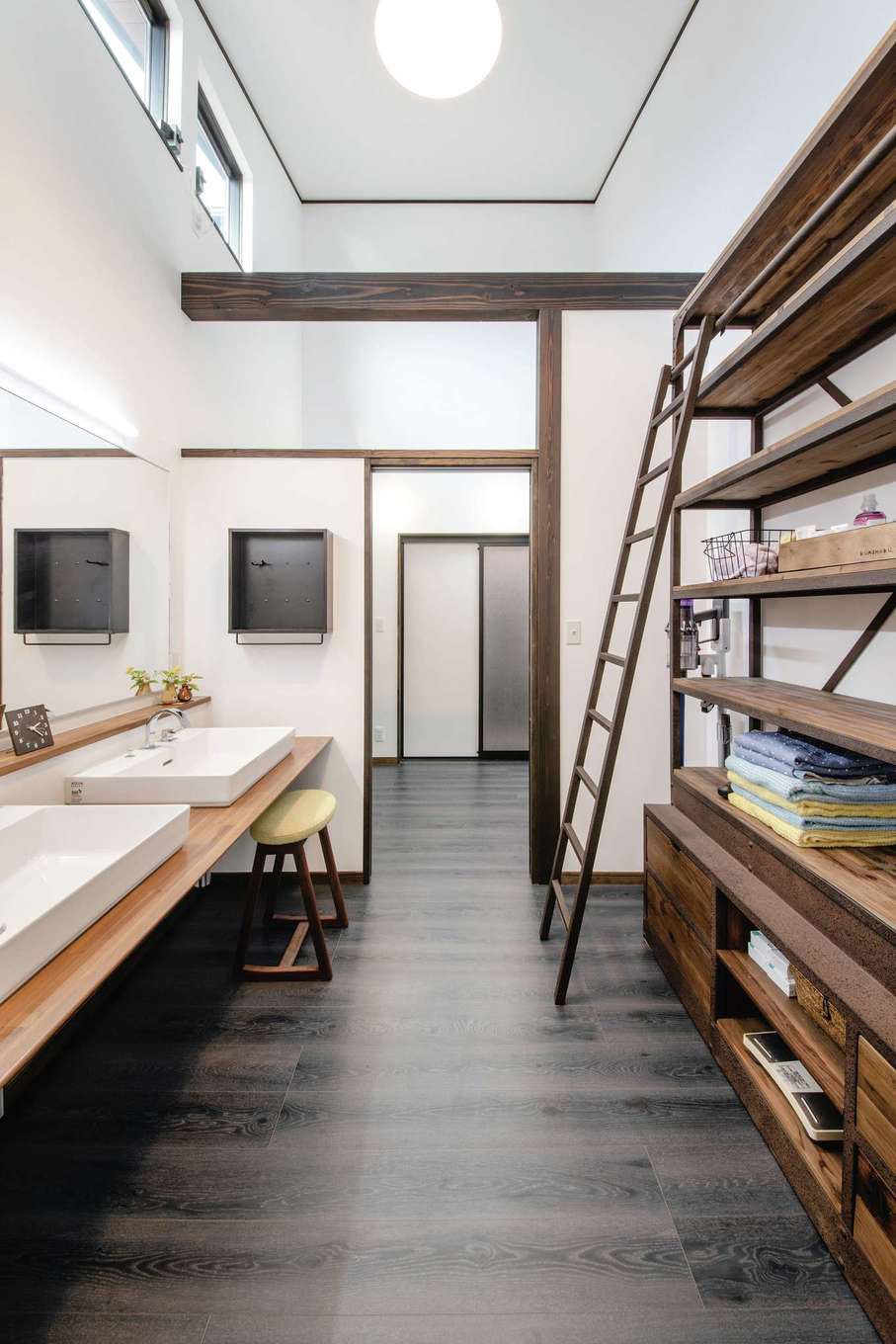 丸洋建設 ハウスオブハウス【デザイン住宅、自然素材、平屋】吹抜けの明るいサニタリー。洗面台に2つのボウルを用意して、朝の混雑を解消。脱衣室と間仕切りできるので、誰かが入浴中でも歯磨きや洗面ができる。壁一面に大容量の“見える収納棚”を造作した