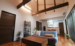 シンプルでモダンなLDKの様子。木目調のフローリングに調和したダークトーンの家具が、落ち着いた雰囲気を演出