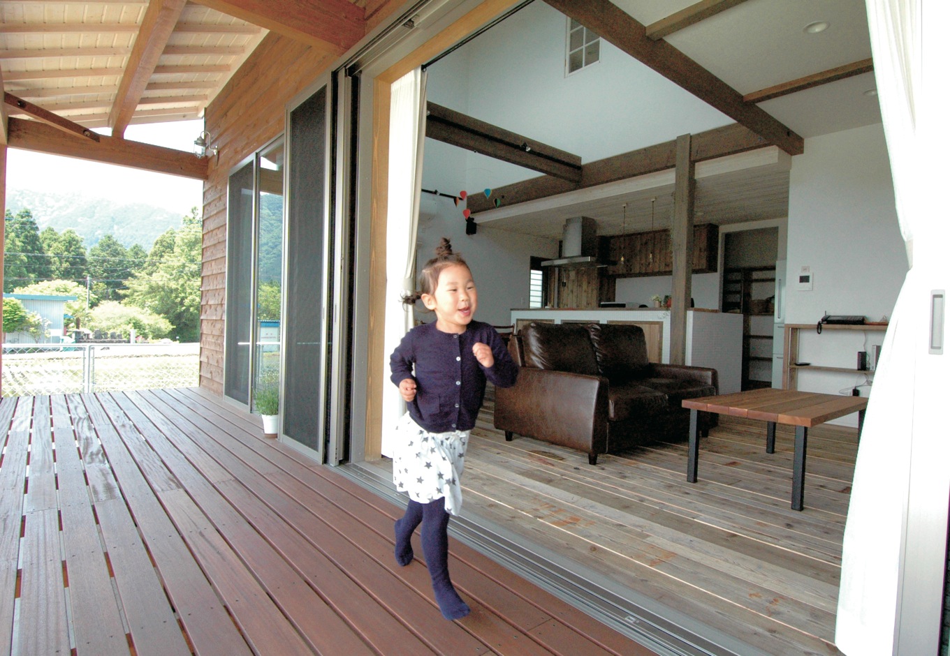 富士ホームズデザイン【デザイン住宅、自然素材、インテリア】フルオープンの掃き出し窓でリビングに繋がるウッドデッキ。屋根付きでいろいろ便利に使えそう