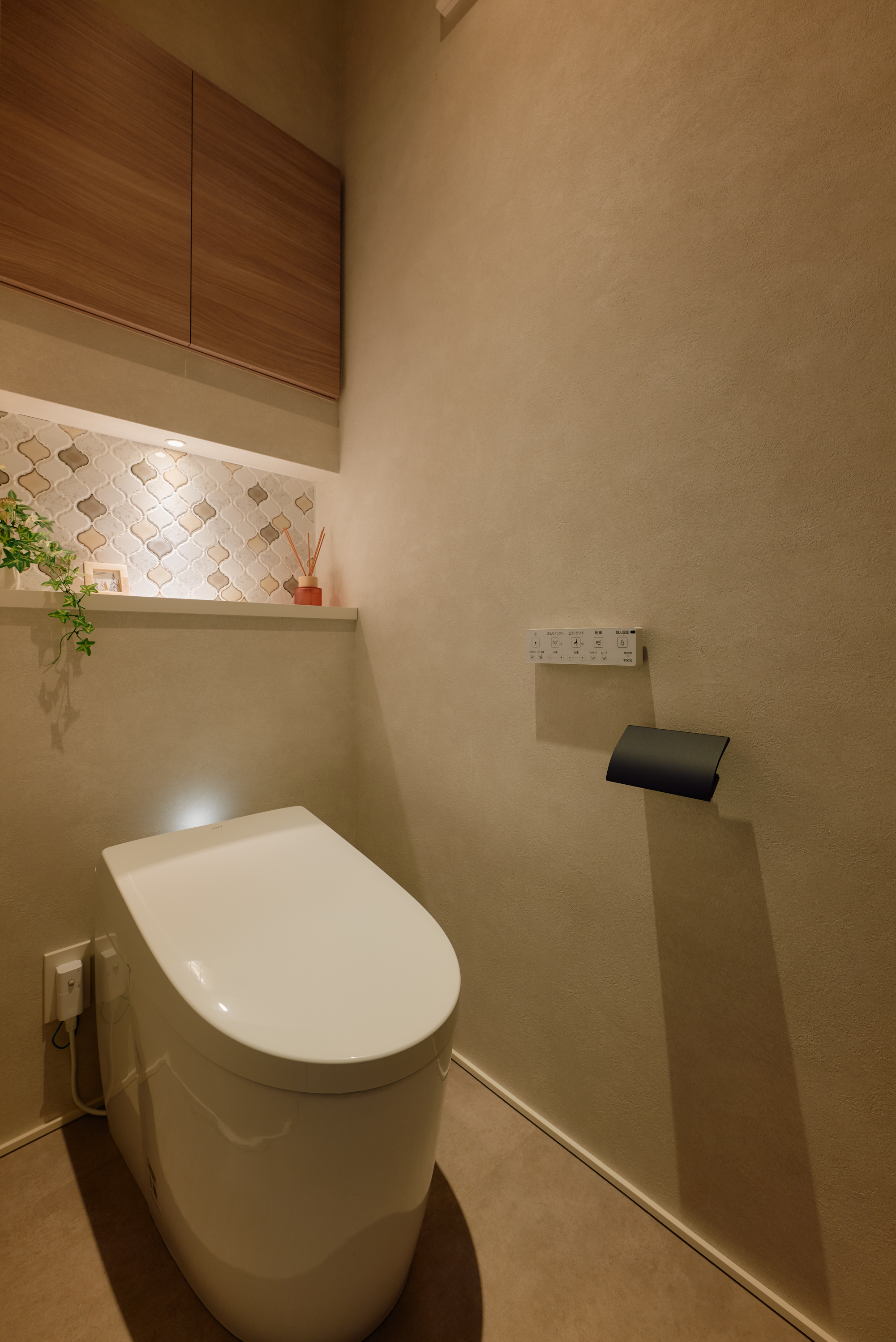 大和ハウス工業中部支社｜温かみのある色合いのトイレ空間。壁面にはアクセントタイルが施され、洗練された印象を与える。収納も設けられ、機能性と美観を両立している。