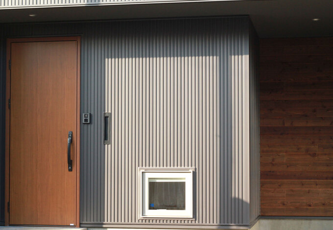 ブラックのガルバリウムと木のコントラストが玄関を飾る