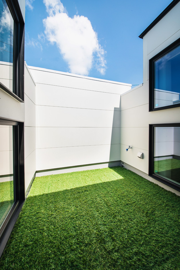 SEIEN ARCHITECT【趣味、建築家、1000万円台】壁を高くしてプライバシーを確保したバルコニー。人工芝を敷いて、自分たちだけのプライベート・ガーデンを実現。ダイニングと畳スペースに窓を設け、開放感を室内に取り込んだ