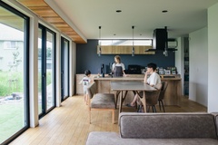 大きな窓から自然光が降り注ぐLDKは、広々とした空間にモダンな家具が配置され、家族がくつろげる開放的な雰囲気である。