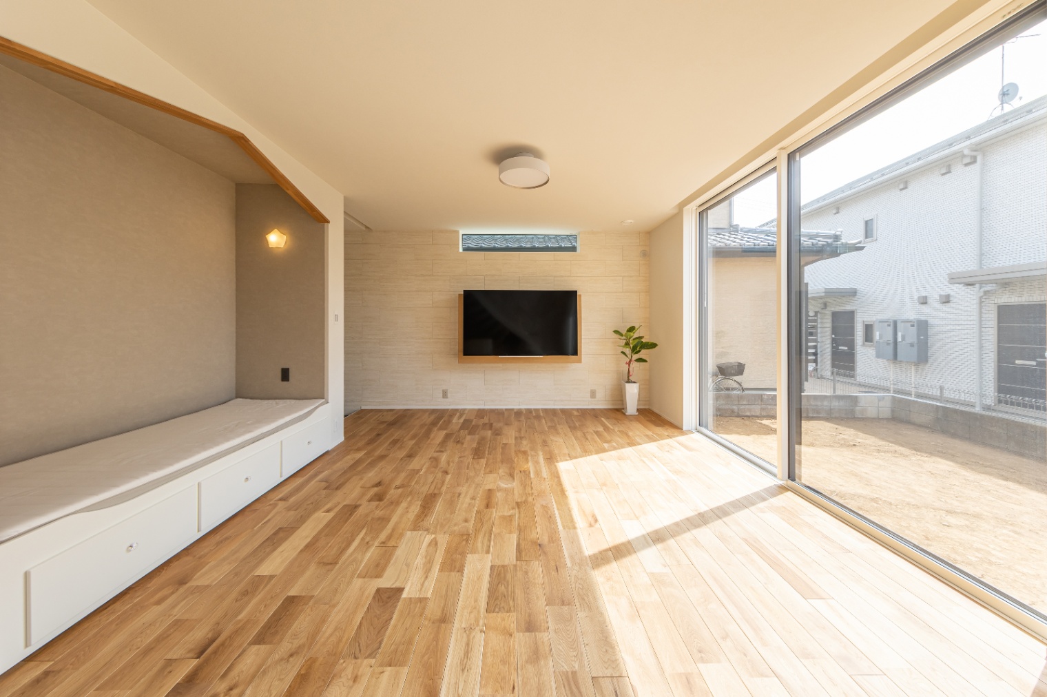 ハルクホーム｜大きな窓から自然光が差し込む開放的なリビングルーム。ナチュラルな色合いのフローリングが温かみを感じさせる。シンプルでありながら、モダンなインテリアが特徴的。