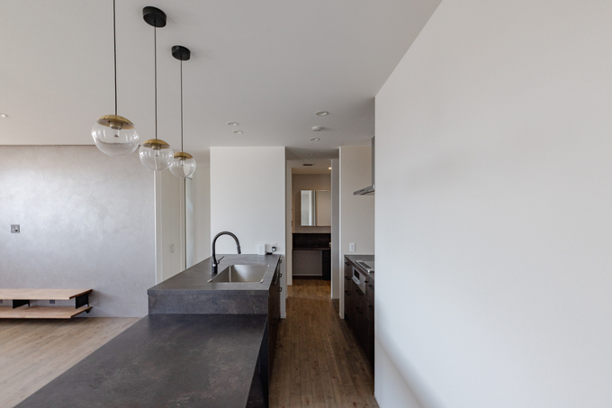 モダンでシンプルなデザインのアイランドキッチン。ペンダントライトがアクセントとなり、開放感を演出している。