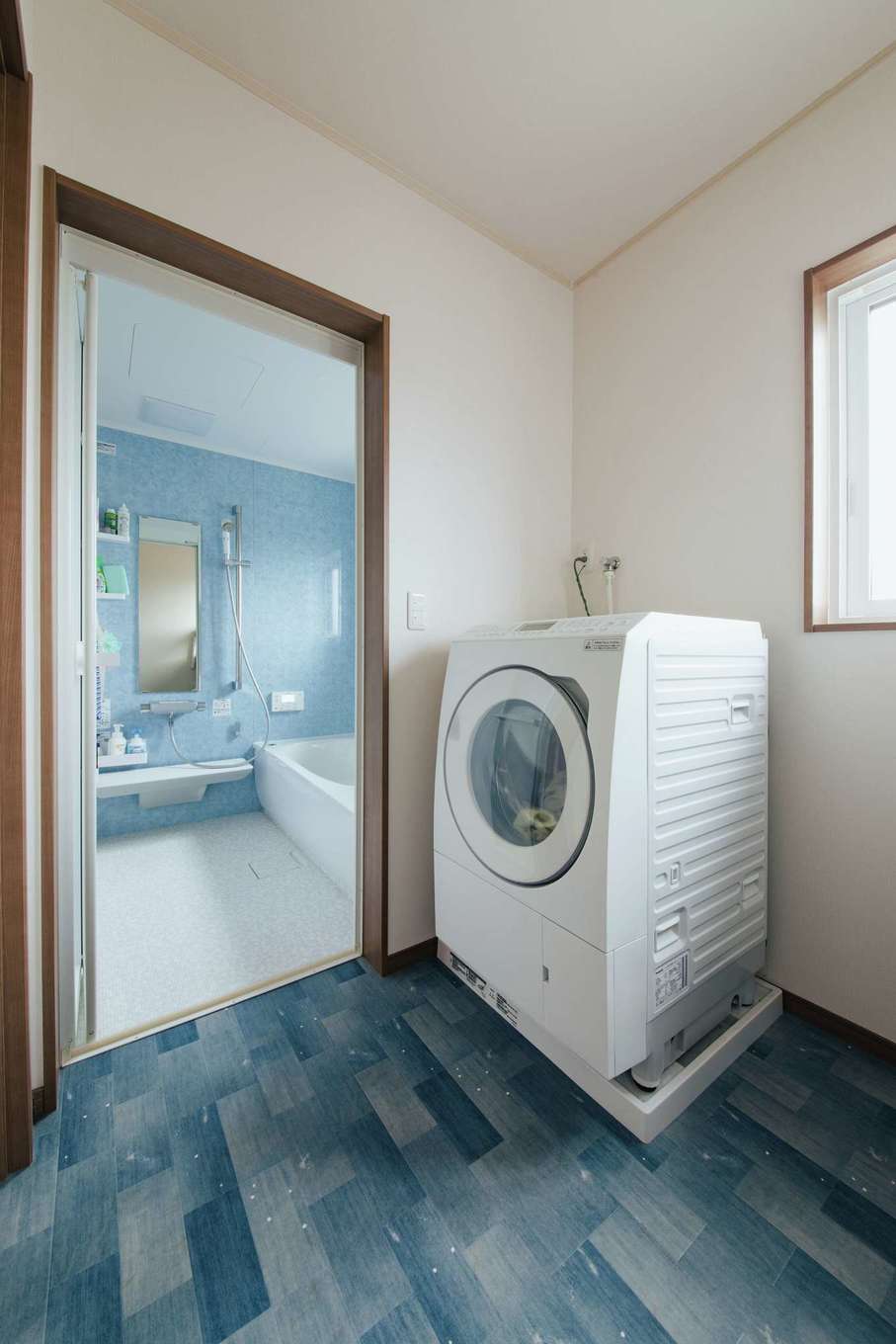 子育て安心住宅 Design Craft Office｜新設された子世帯の浴室、脱衣＆洗濯室はさわやかな仕上がり。入浴中も使用できるよう、洗面台は分離させている