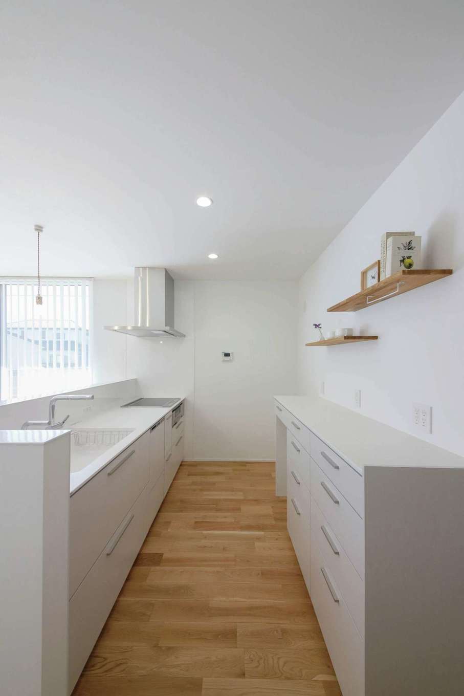 ひだまり工房【デザイン住宅、間取り、平屋】「引き算の美学」を体現した、真っ白で無駄のないキッチンは奥さまのこだわり。オーク材の床の経年変化も楽しみのひとつ
