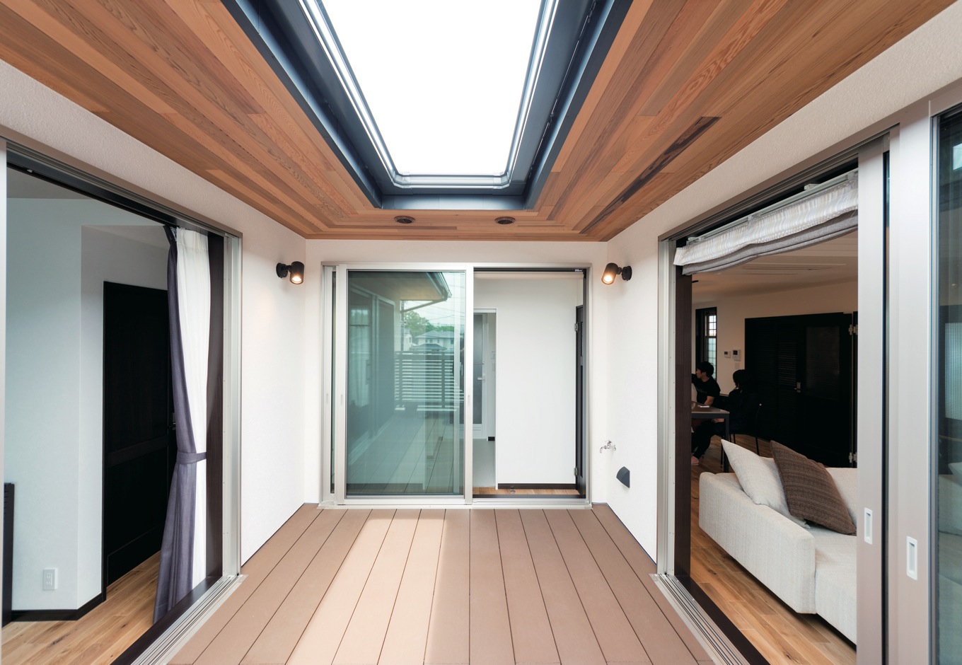 -delphi- デルフィ（藤井建築事務所） 【デザイン住宅、二世帯住宅、建築家】3つの空間に囲まれたウッドデッキは多彩な役割。広さ、楽しさを提供しながら、家族のつながりが育まれていく。深い軒は夏の日差しと雨を防ぎ、快適を室内に運ぶ