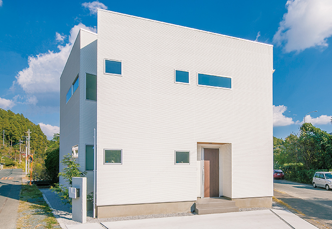 二等辺三角形に建つ白いスタイリッシュな外観