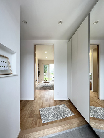 玄関にはニッチと大きな鏡のついた壁面収納を配置した