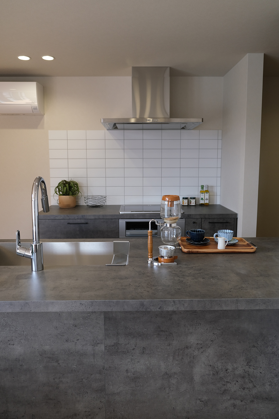 BASE.trip【デザイン住宅、間取り、インテリア】キッチンは人気のGRAFTECT。限られた空間を有効活用するには壁付けのキッチンがオススメだけれど、家族の様子を見ながら料理したいという奥さまの希望で、シンクとコンロが別々のⅡ型キッチンを採用。壁に白いタイルを張り、ニュアンスを出した