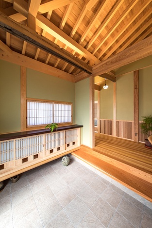 上部に古材を再利用した和風の玄関ホール。銘木タガヤサンの一枚板天板と無双窓格子戸のある通気口付きで湿気がこもらない下駄箱。