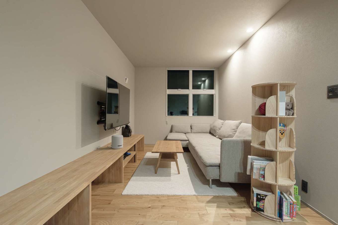 住家 JYUKA【デザイン住宅、趣味、間取り】おこもり感のあるリビングは、家族がほっとできる場所。テレビ下に収納を希望したところ、ベンチや飾り棚としても機能するロングスパンの造作収納が提案された。正面の窓は富士山が見える立地を活かして計画