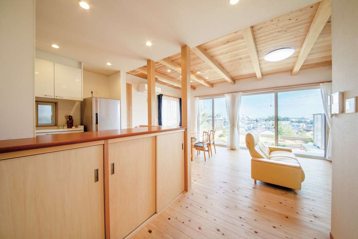 水田建設【自然素材、狭小住宅、間取り】キッチン前のカウンター下は収納に利用。LDKの大開口から眺める景色が抜群