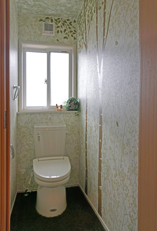 こちらのトイレは天空に浮かぶ島の森の中をイメージ。グリーンの壁紙に、施主さんが自ら貼った木のステッカーがさらに雰囲気を作り出している