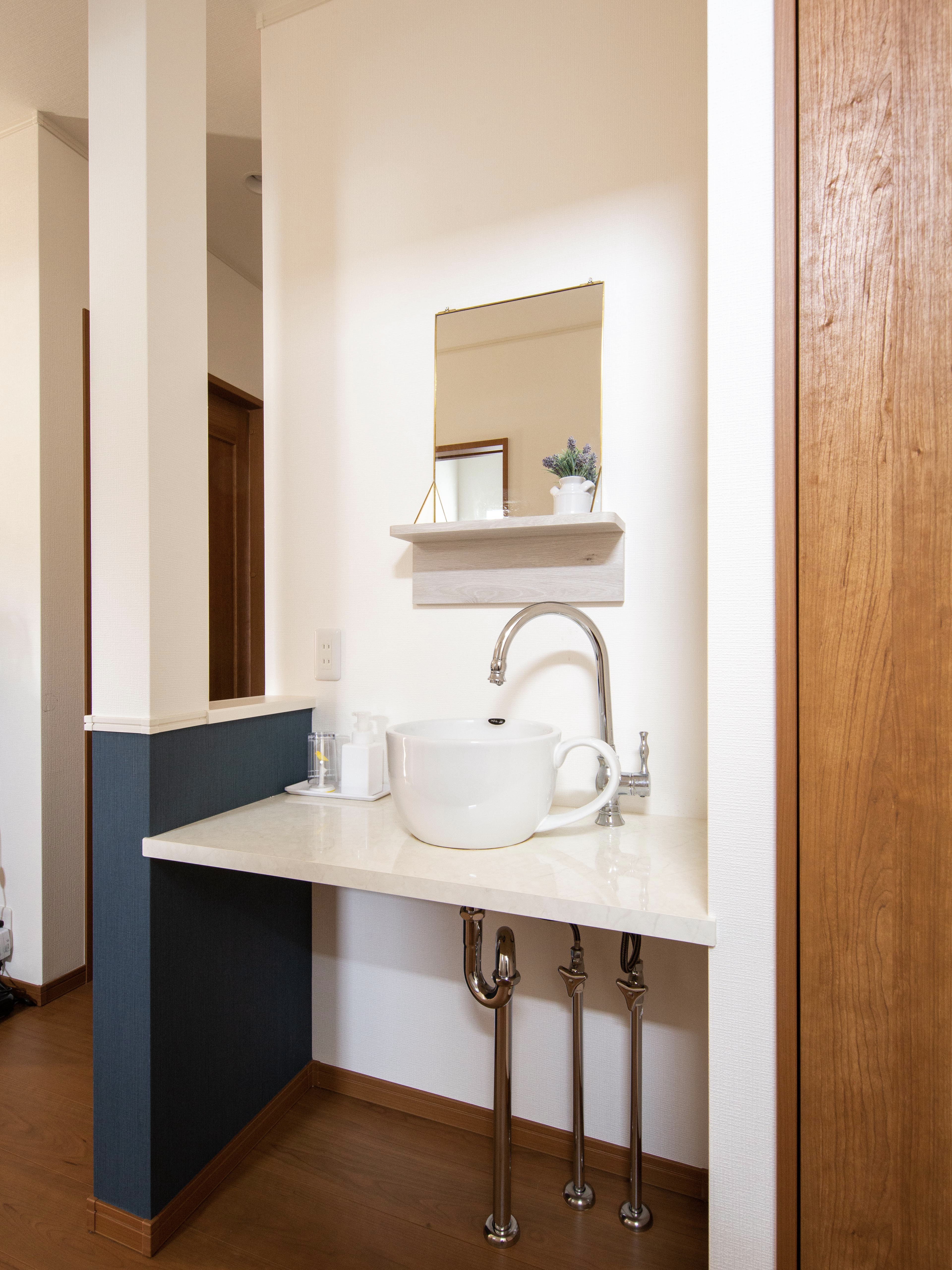 エスホーム｜事務所連絡口近くに設置した洗面台のシンクは可愛いコーヒーカップ型。全体的にシンプルなデザインで、小物置き場も完備しているため、利便性が高い。