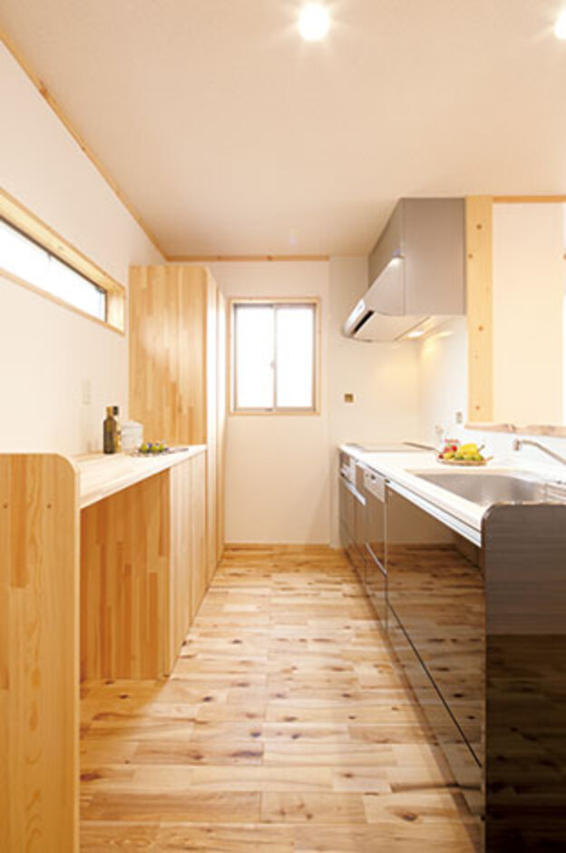 たっぷりの収納や便利なカウンターも、無垢材で造作。横スリットの窓から光が差し込み、明るい キッチン